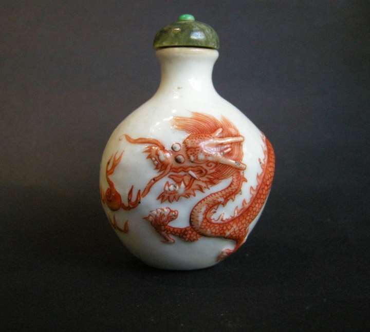 Snuff bottle porcelain with a low relief a Dragon in iron red